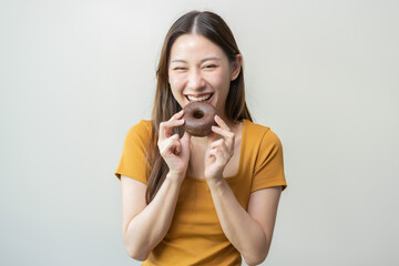 Fototapeta premium Portrait of pretty attractive asian young teenage woman holding chocolate, donut, doughnut, female emotion enjoy sweet. Dieting, diet for loss weight to slim. Isolated on white background, copy space