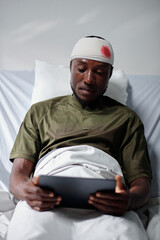 Military man with head injury watching video on tablet computer