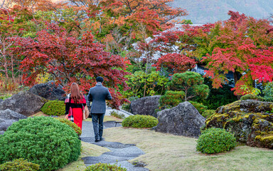 Young couple are walking together in beautiful automn forerest, Hakone, Japan