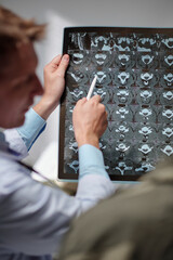 Radiologist showing x-ray image of spine discs to soldier and explaining recovery process