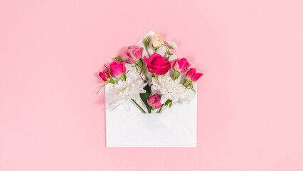 Natural red and white flowers buds in open white envelope. Valentine's, mother's day holiday,...