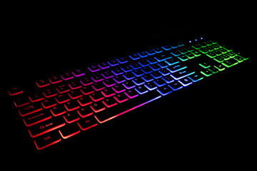 Game keyboard with color RGB backlight on black background. Selective focus.