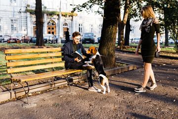 man with a beagle greets a young blonde in the park