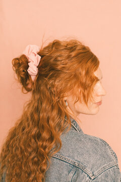 Portrait of redhead woman in levi jacket with pink scrunchie in 
