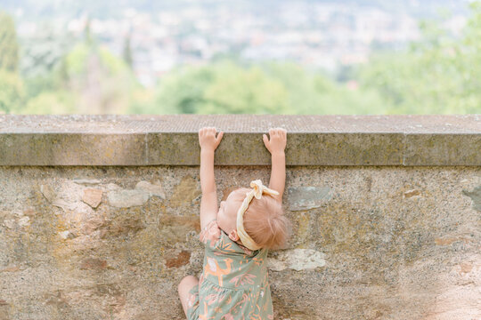 Baby girl toddler plays, indulges and is naughty in a park