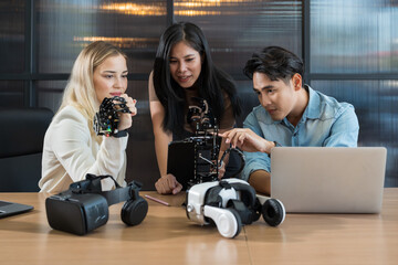 Male and female engineer working with AI robot arm system project in workshop. Male engineer using laptop computer for training Programmable logic controller robotics arm system project