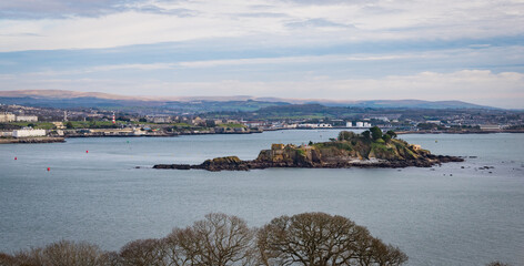View across Plymouth Sound from Mount Edgecombe country park with Drake's Island in the foreground.