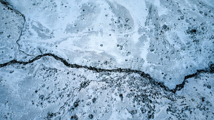 drone view of a river with a field covered by snow