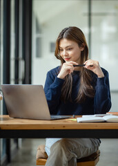 Businesswoman hands working with document papers and laptop at work desk in office.