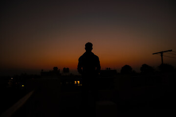 silhouette of a person standing on sunset 