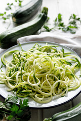Zucchini noodles, zoodles on a white plate, close-up view. Vegetable noodles