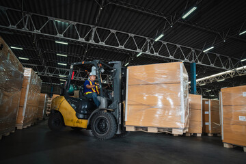 Warehouse worker workers with forklift in a warehouse. Use forklift operator moves packages....