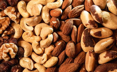Mix with different types of nuts on a wooden plate. Nuts, cashews, almonds and Brazilian nuts....