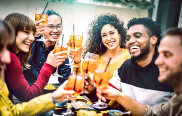 Friends toasting cocktails at bar restaurant - Life style concept with young people having fun together sharing drinks on happy hour at garden party