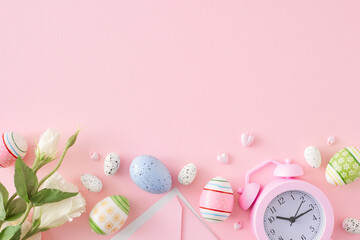 Happy easter concept. Flat lay composition made of colorful eggs, flowers, envelope and alarm clock on pastel pink background with empty space. Spring holiday card idea.