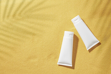 Skincare products concept. Flat lay photo of cosmetic bottles without label, green tropical leaves...