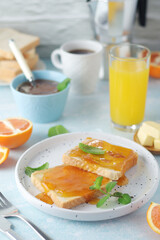 Sandwiches with marmalade, orange juice and coffee ready for breakfast	