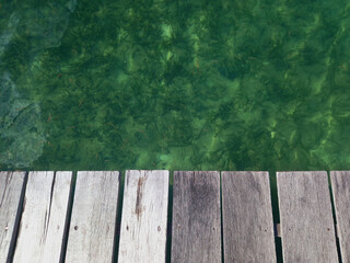 close-up of pontoon wooden slats. Footbridge over emerald waters. Tropical nature of the French...