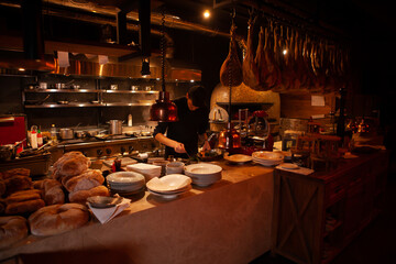 Professional cook. chef in black apron and cap working in restaurant kitchen
