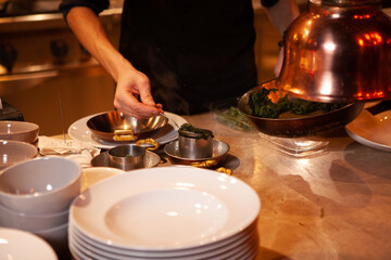 Professional cook. chef in black apron and cap working in restaurant kitchen
