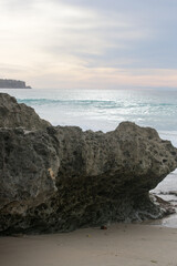 Blue and yellow clouds at the beginning of sunset over calm blue ocean
