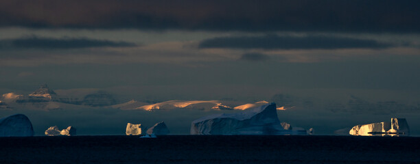 Panorama of sunrise over icebergs
