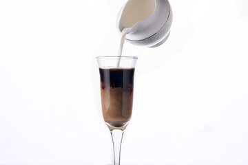 Milk is poured into a glass of coffee