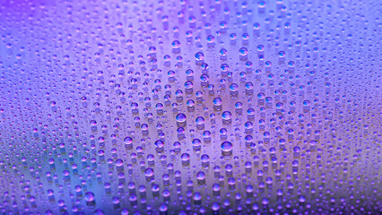 Water drops. Texture of the drops. Abstract gradient background. Multicolored blue pink rainbow gradient. Heavily textured image. Shallow depth of field. Selective focus