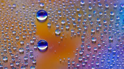 Water drops. Droplet texture. Abstract gradient backdrop Multicolored blue-gold rainbow gradient. Heavily textured image. Shallow depth of field. Selective focus