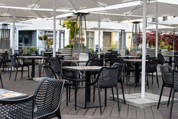 Tables of traditional outdoors cafe in European city in summer day