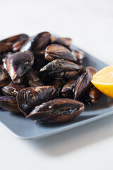 Close up of a plate with freshly coocked mussels on dining table. High quality photo