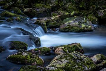 Steine im Fluss mit kleinem Wasserfall