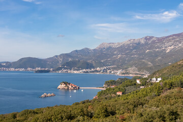 Obraz premium Aerial view of idyllic island Sveti Stefan (St. Stephen) in the Bay of Budva seen from Saint Sava, Adriatic Mediterranean Sea, Montenegro, Europe. Summer vacation at seaside with Dinaric Alps in back