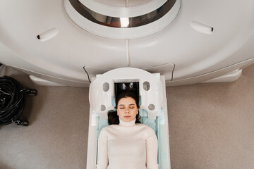 CT scan of brains of girl in medical clinic. Woman is doing computed tomography x-ray examination...