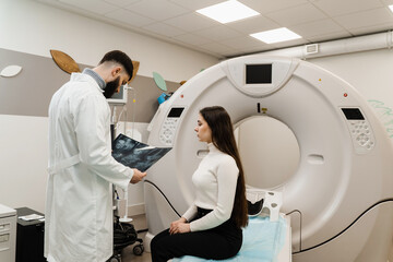 CT Doctor consulting patient and showing chest x-ray to patient in computed tomography room. CT...