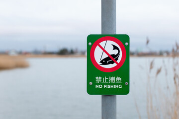 Chinese fishing prohibited sign near lake - NO FISHING