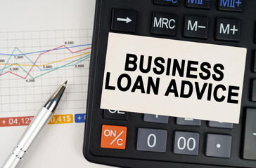 On the business chart lies a pen, a calculator and a business card with the inscription - BUSINESS LOAN ADVICE