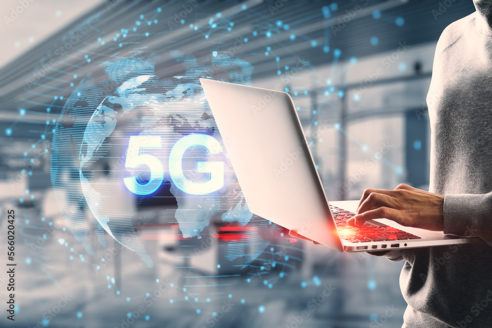 Poster close up of hands using laptop with globe and 5g hologram on blurry office interior background. tele