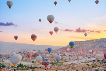Landscape of fabulous Kapadokya. Colorful flying air balloons in sky at sunrise in Anatolia....