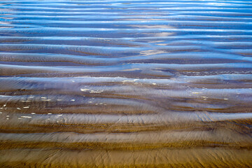 Traces from the waves in the sand on the seashore.