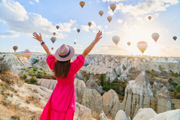 Girl traveler with open arms vacations beautiful destination in Goreme, Turkey. Fabulous Kapadokya...