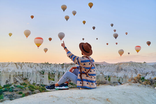 Man traveler vacations beautiful destination in Goreme, Turkey. Fabulous Kapadokya with flying air balloons at sunrise, Anatolia