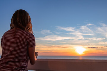 Happy woman on balcony in luxury hotel in Budva Riviera with scenic view near idyllic Sveti Stefan...