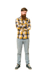 Young adult redhead man with a long beard standing full body isolated suspicious, uncertain, examining you.