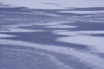 Snow scene of frozen lake in winter. Artistic picture of lake pattern.