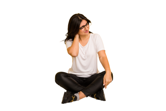 Young indian woman sitting on the floor cut out isolated having a neck pain due to stress, massaging and touching it with hand.