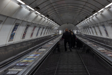 Fototapeta premium People riding the escalator of the Prague metro system. Ungerground stairs in the metro of Prague.