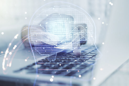 Double exposure of creative artificial Intelligence symbol with hands typing on laptop on background. Neural networks and machine learning concept