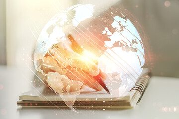 Double exposure of abstract digital world map and man hand writing in notepad on background, big data and blockchain concept