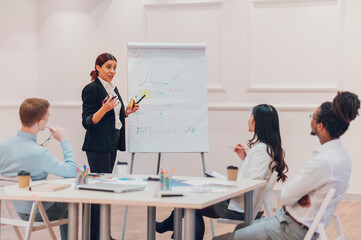 Caucasian businesswoman holding a meeting to his diverse colleagues in an office